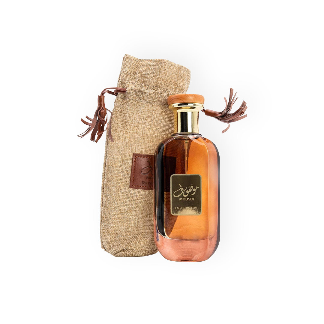 Packshot du parfum Mousuf 100 ml par Ard Al Zaafaran, avec un flacon en verre ambré aux détails dorés, accompagné d'une pochette en toile naturelle avec cordons en cuir, reflétant un style artisanal et raffiné.